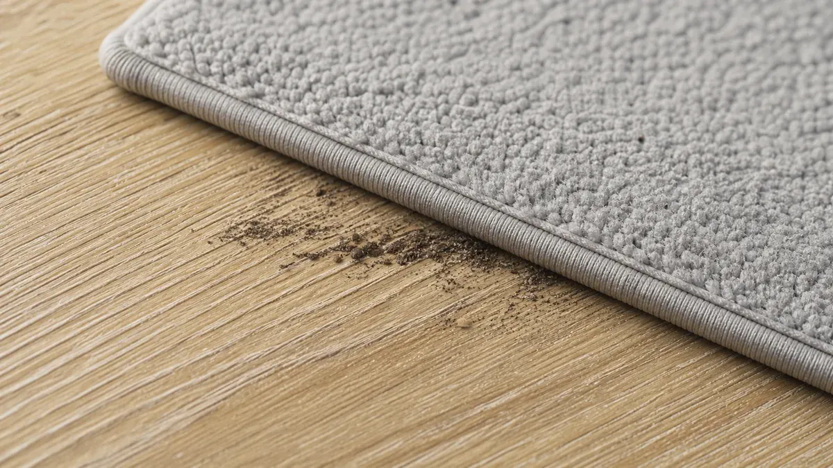 Microfiber fibers cleaning dirt from textured luxury vinyl plank flooring